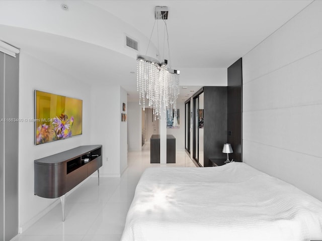 bedroom featuring light tile patterned flooring and a chandelier