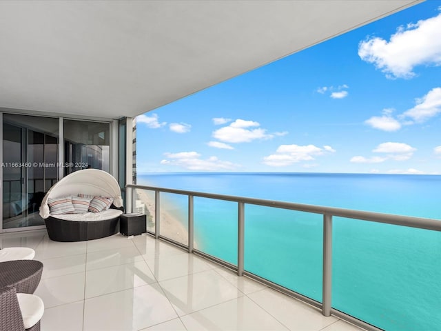 balcony featuring a water view and a beach view