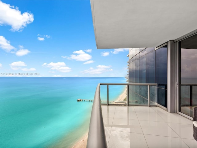 balcony featuring a water view and a beach view