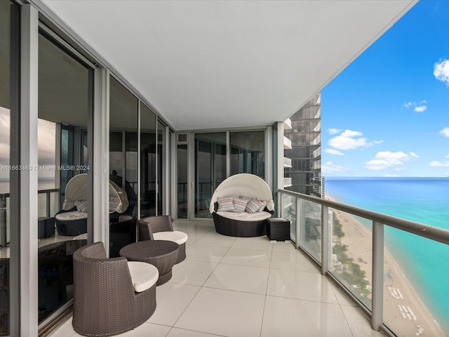 balcony featuring a view of the beach and a water view