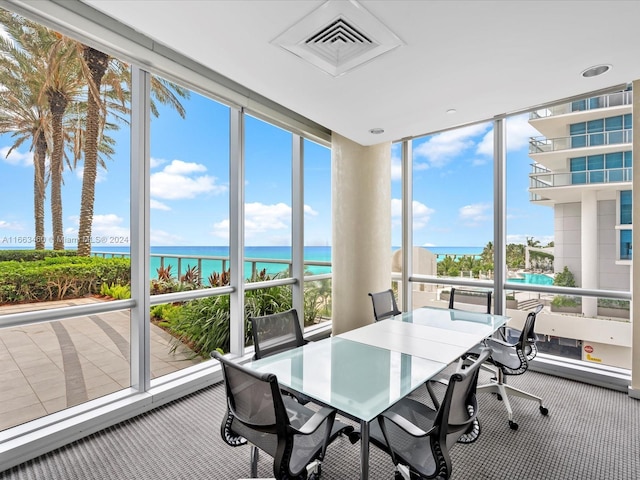 sunroom featuring a water view and plenty of natural light