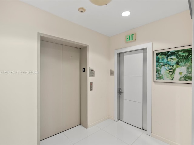 hall featuring elevator and light tile patterned floors