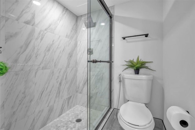 bathroom with a shower with door and toilet