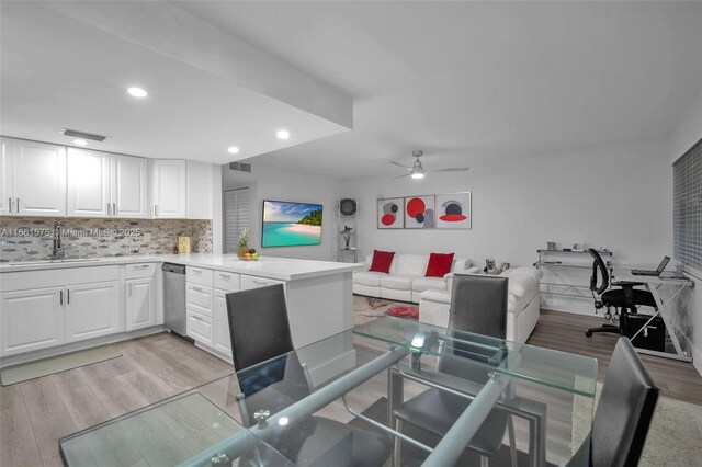 living room featuring ceiling fan, sink, and light wood-type flooring