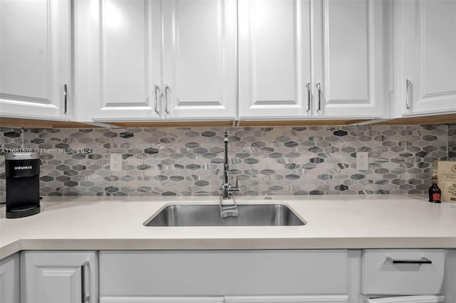 kitchen with white cabinetry, sink, and backsplash