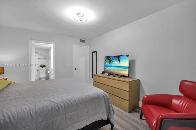 bedroom with light hardwood / wood-style floors and ensuite bathroom