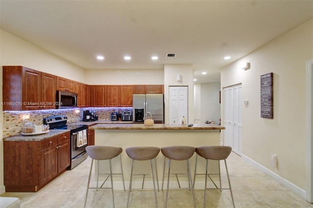 kitchen featuring a kitchen bar, tasteful backsplash, a center island, and stainless steel appliances