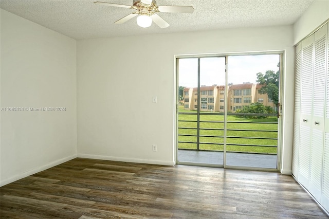 empty room featuring a textured ceiling, ceiling fan, dark hardwood / wood-style flooring, and plenty of natural light