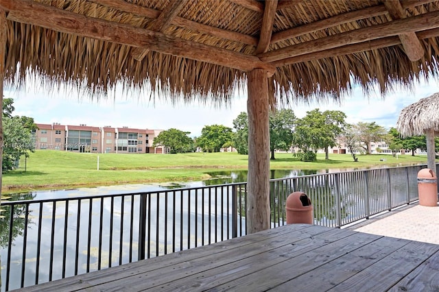 wooden terrace featuring a gazebo, a yard, and a water view