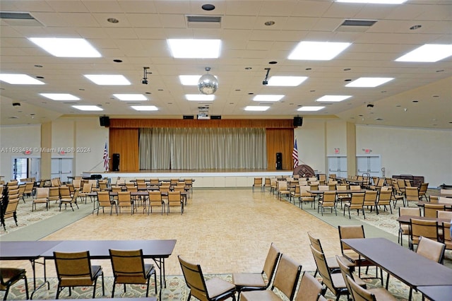 carpeted dining room with a paneled ceiling