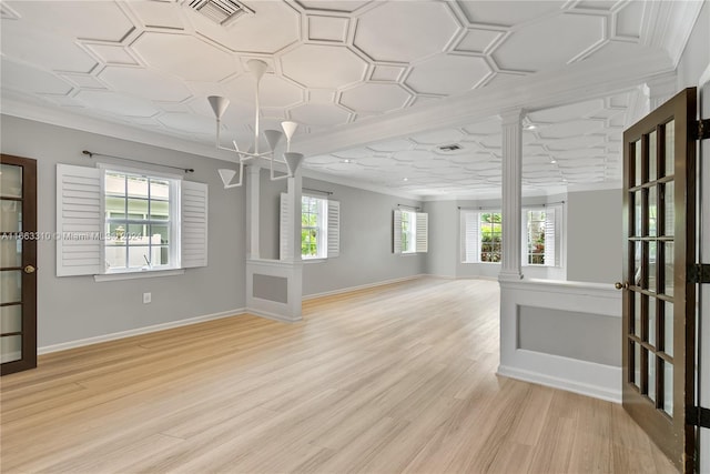 interior space featuring visible vents, baseboards, light wood finished floors, ornamental molding, and ornate columns