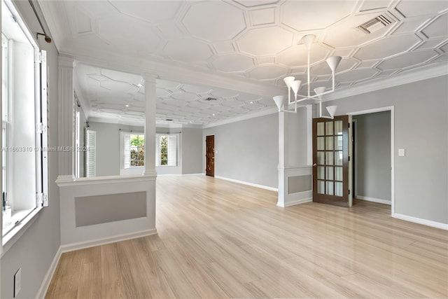 unfurnished room with baseboards, crown molding, and decorative columns