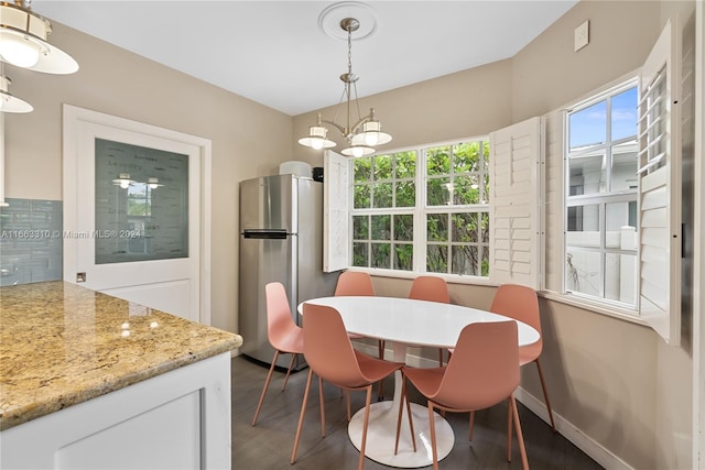 dining room featuring dark wood-style floors, a notable chandelier, and baseboards