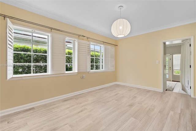 unfurnished room featuring light wood-type flooring, ornamental molding, and baseboards