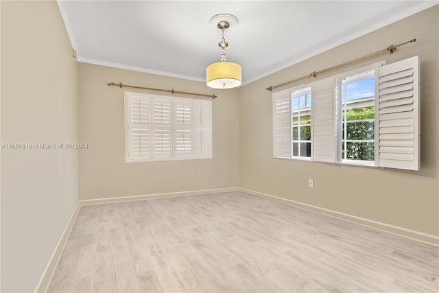 unfurnished room featuring wood finished floors, ornamental molding, and baseboards
