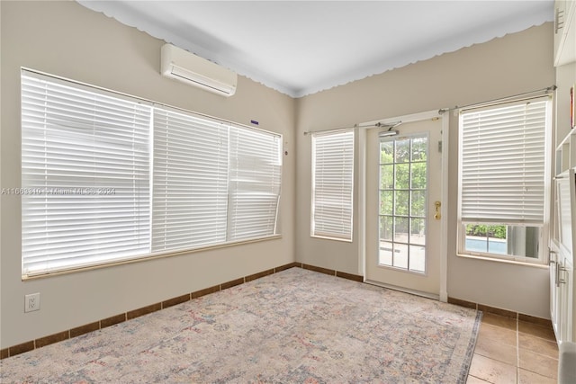 unfurnished room featuring baseboards and a wall unit AC