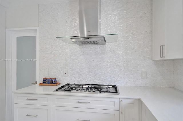 kitchen featuring white cabinets, stainless steel gas cooktop, extractor fan, and tasteful backsplash