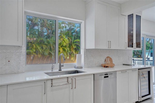 kitchen featuring sink, wine cooler, stainless steel dishwasher, decorative backsplash, and white cabinetry