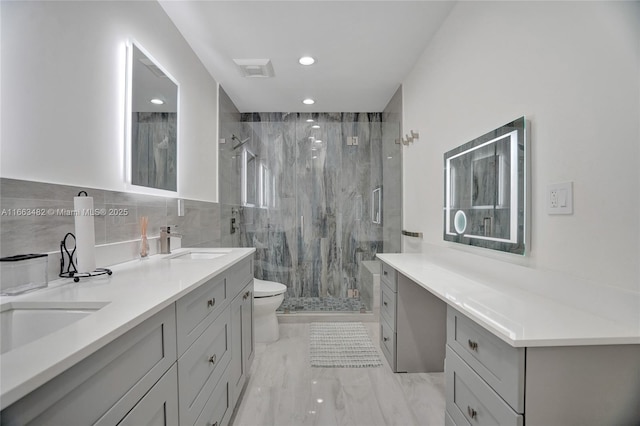 bathroom featuring tile walls, vanity, an enclosed shower, and toilet