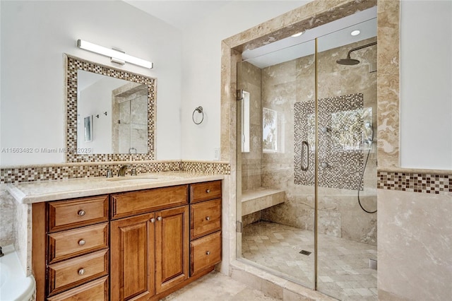 bathroom with backsplash, vanity, and tiled shower