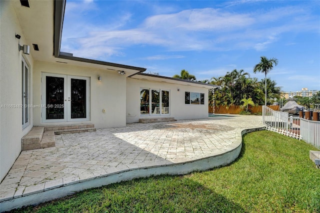 back of house featuring a yard, a patio, and french doors