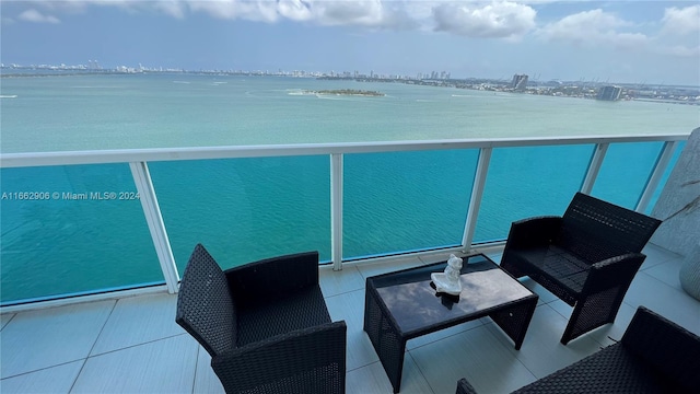 balcony with an outdoor living space and a water view