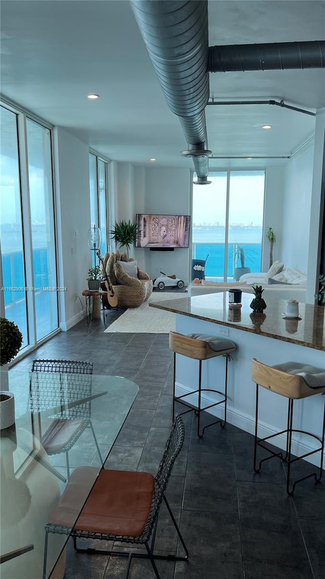 kitchen with a kitchen breakfast bar, dark tile patterned floors, and a water view