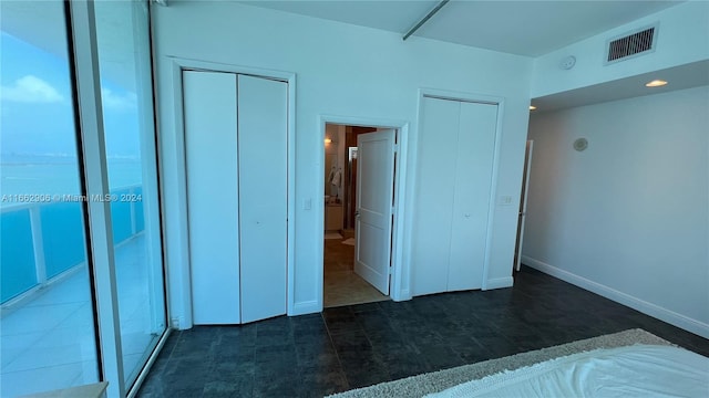 unfurnished bedroom with two closets