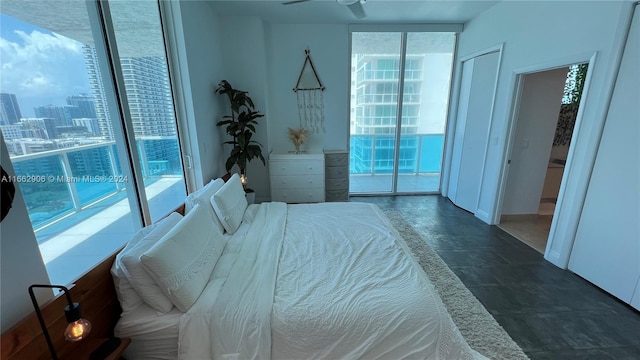 bedroom with ceiling fan, a wall of windows, and access to exterior