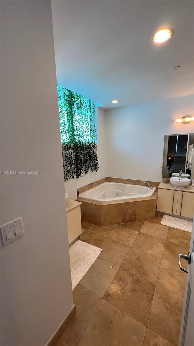 bathroom with tiled tub and vanity