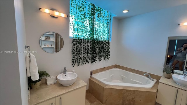 bathroom featuring tiled bath and vanity