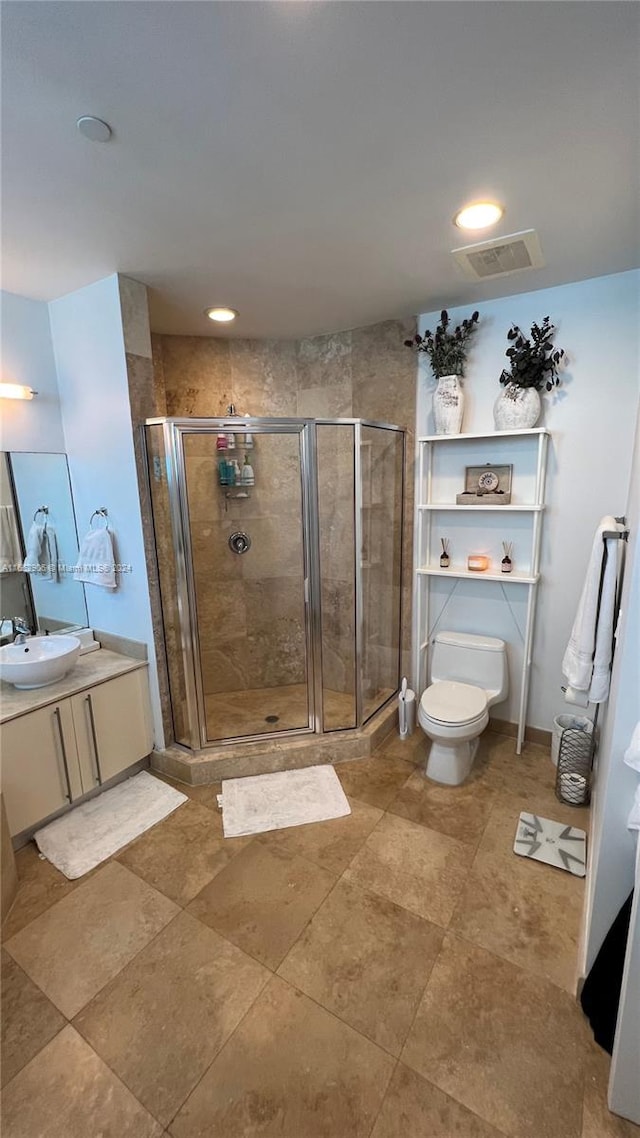 bathroom with an enclosed shower, vanity, and toilet