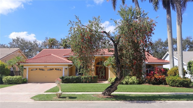 mediterranean / spanish house featuring a garage and a front lawn