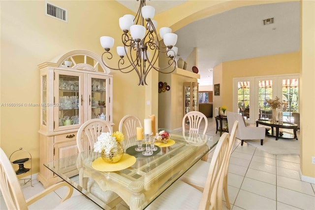 dining space featuring light tile patterned floors, a high ceiling, and a chandelier