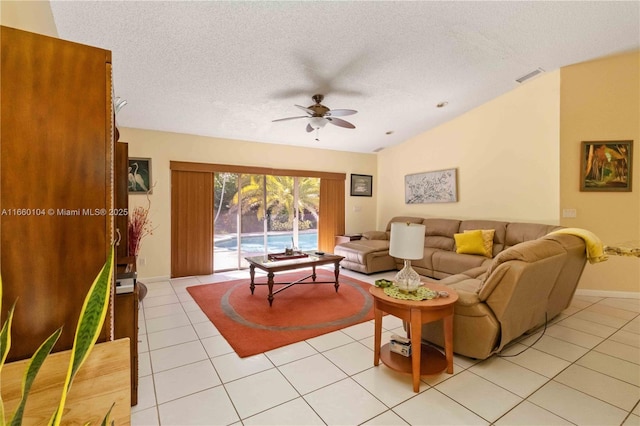 living room with light tile patterned flooring, vaulted ceiling, ceiling fan, and a textured ceiling