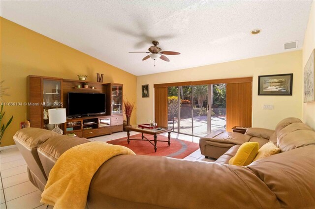 living room featuring ceiling fan, light tile patterned floors, and a high ceiling