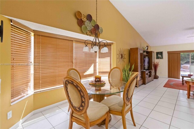 tiled dining room with high vaulted ceiling and a notable chandelier