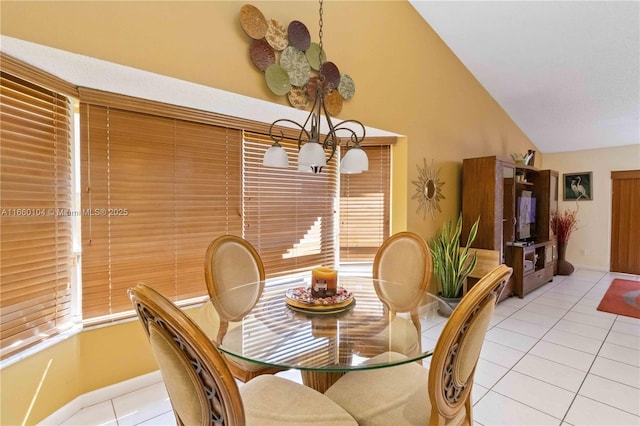 tiled dining area with an inviting chandelier and high vaulted ceiling