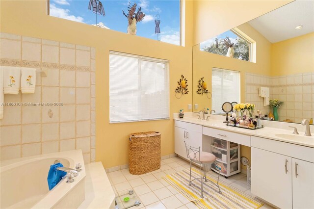 bathroom featuring tile patterned flooring, tiled bath, a towering ceiling, and vanity