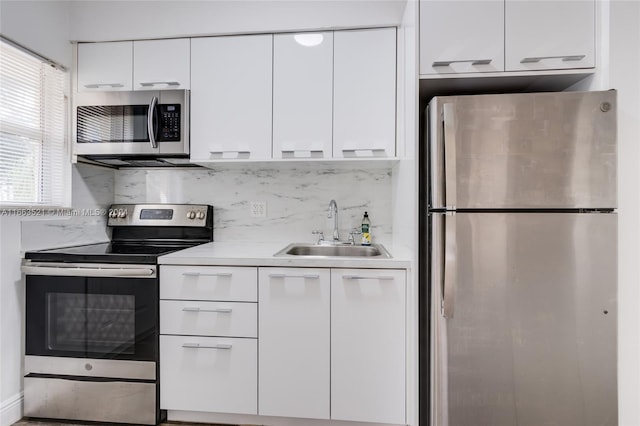 kitchen with white cabinets, backsplash, appliances with stainless steel finishes, and sink