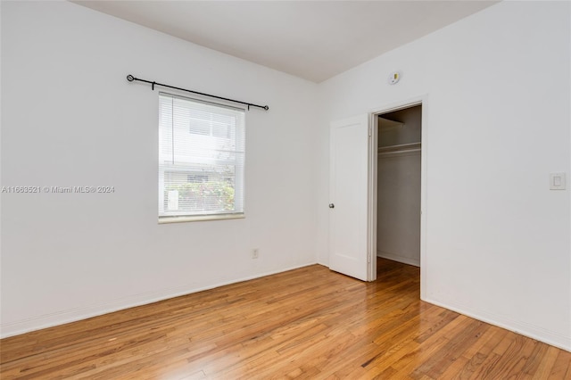 unfurnished bedroom with light hardwood / wood-style flooring and a closet