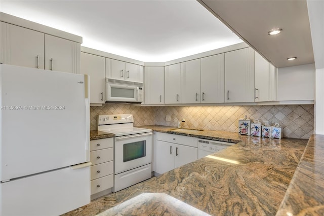 kitchen featuring white appliances, white cabinetry, dark stone countertops, and tasteful backsplash