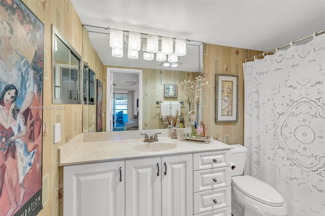 bathroom with vanity, wooden walls, toilet, and a shower with shower curtain