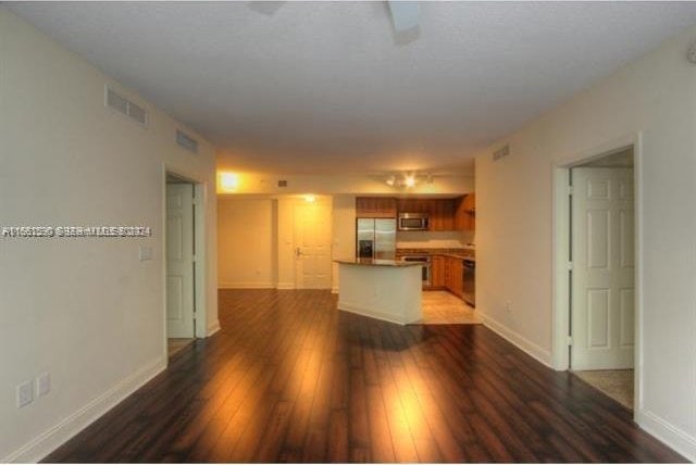 unfurnished living room with dark wood-type flooring