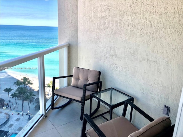 balcony featuring a water view and a beach view