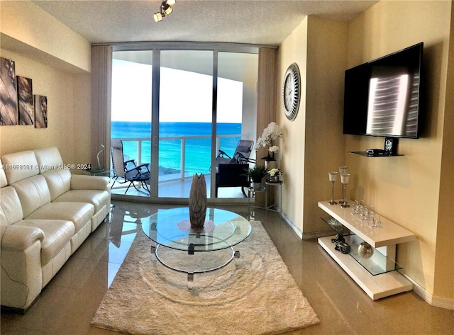 living room with a textured ceiling, tile patterned floors, and expansive windows