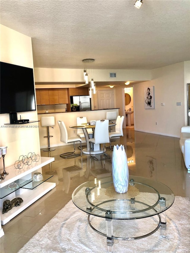 living room with a textured ceiling and tile patterned floors