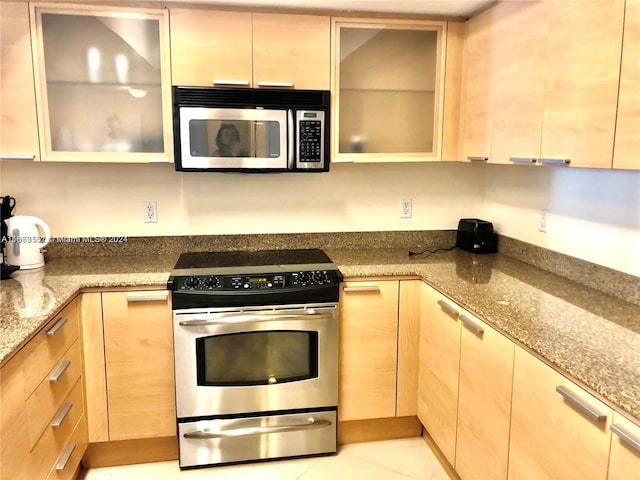 kitchen featuring light brown cabinetry, light stone countertops, appliances with stainless steel finishes, and light tile patterned floors