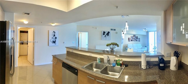 kitchen with appliances with stainless steel finishes, sink, and light tile patterned floors