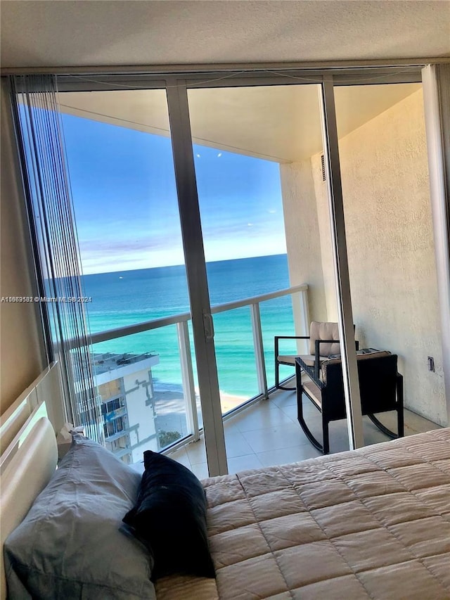 bedroom with a water view and a beach view